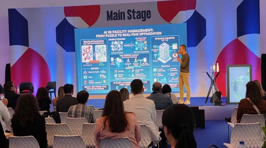 Speaker on the Interclean Main Stage presenting an infographic on AI in facility management